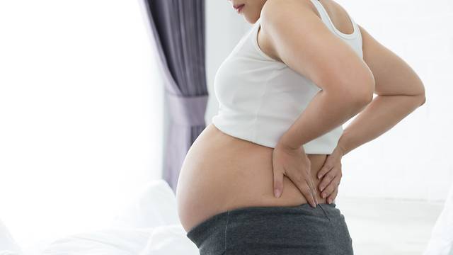 picture of woman stretching her pregnancy back pain 